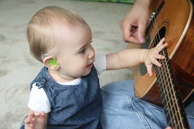 Deaf Child Playing Guitar with Adult