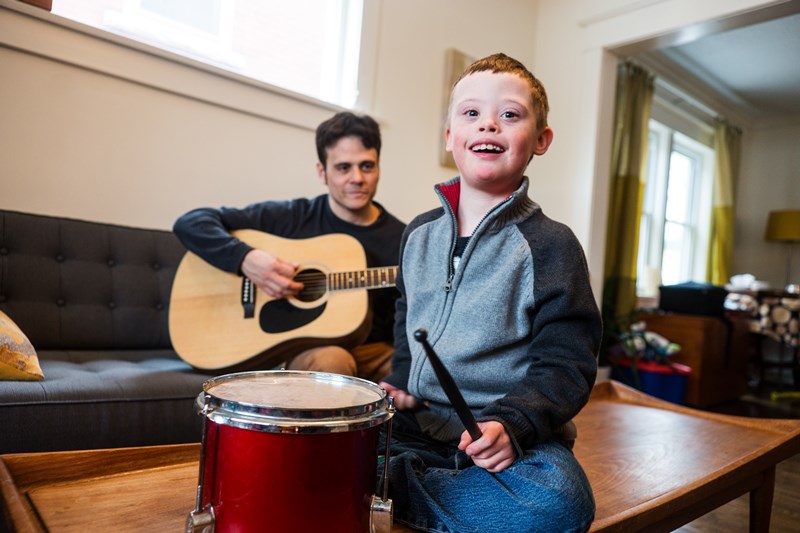 Man Playing Guitar and Young Boy with Drum