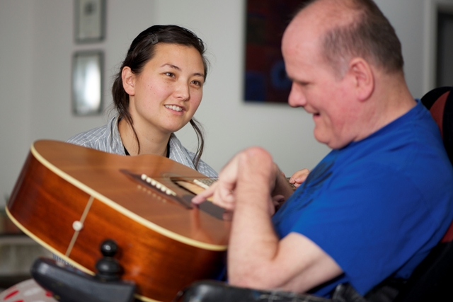 Woman Helping a Man Play Guitar